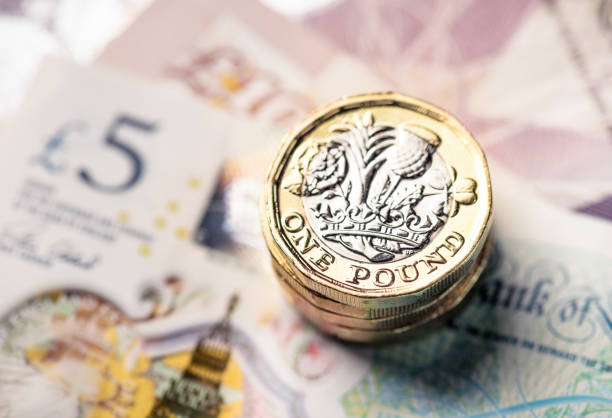 великобритания один фунт монет и банкнот - one pound coin british currency coin paper currency стоковые фото и изображения