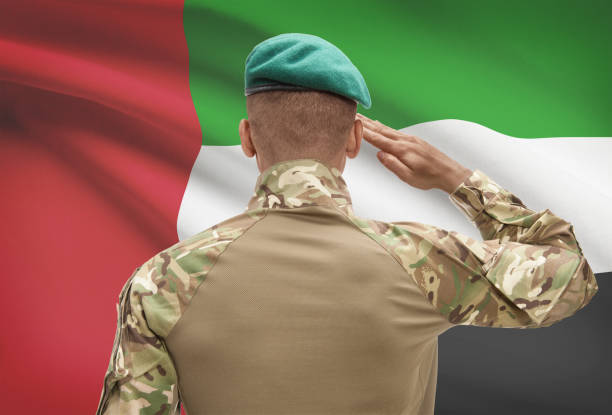 Dark-skinned soldier with flag on background - United Arab Emirates stock photo