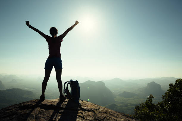 istock cheering successful woman hiker open arms on sunrise mountain top 688527616