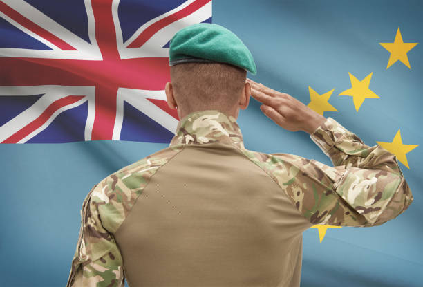 istock Dark-skinned soldier with flag on background - Tuvalu 688527736