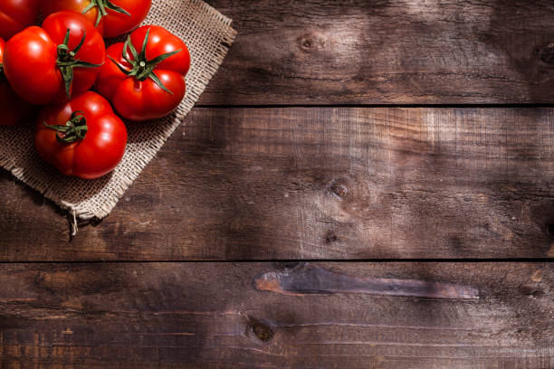 tomate na mesa de madeira rústica - heirloom tomato organic tomato rustic - fotografias e filmes do acervo
