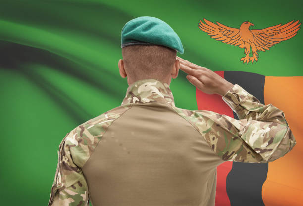 istock Dark-skinned soldier with flag on background - Zambia 688530876