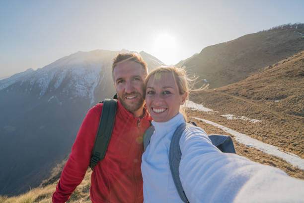 istock Young couple hiking take selfie on mountain top 688548088