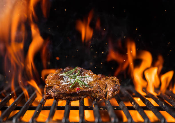 istock Beef steak on the grill grate, flames on background 688548418