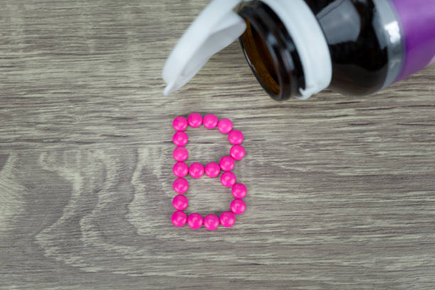 istock Pink pills forming shape to B alphabet on wood background 688548598