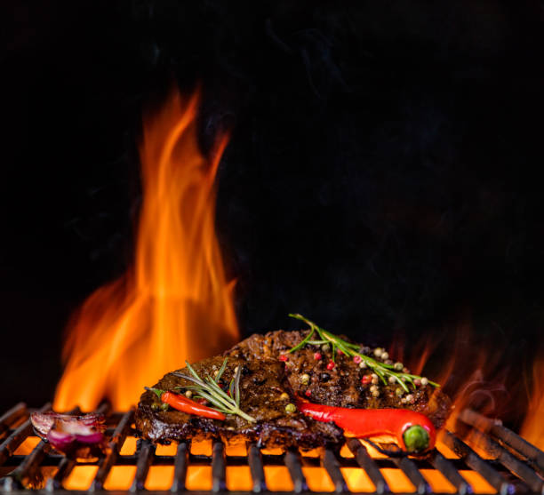 istock Beef steaks on the grill grate, flames on background 688548652