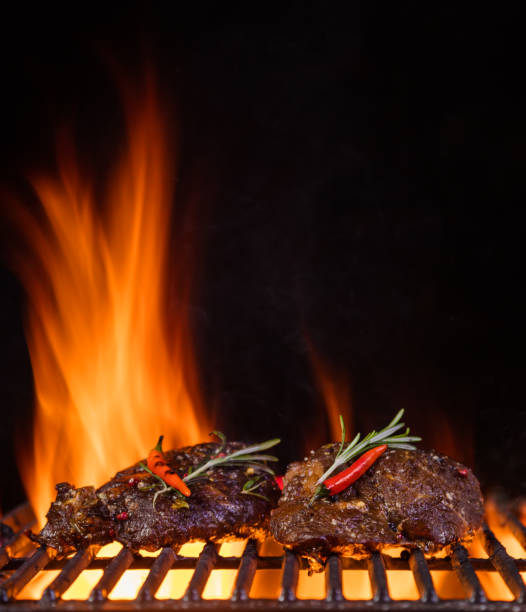 istock Beef steaks on the grill grate, flames on background 688548706