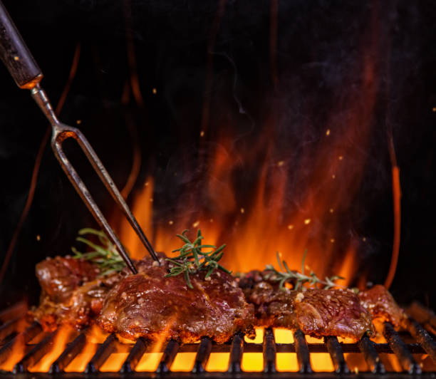 istock Beef steaks on the grill grate, flames on background 688548866