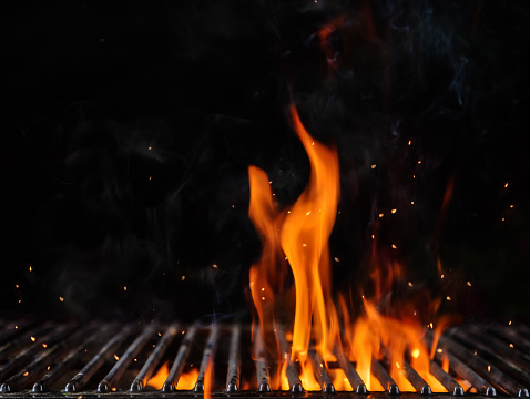 Empty flaming charcoal grill with open fire, ready for product placement. Concept of summer grilling, barbecue, bbq and party. Black copyspace