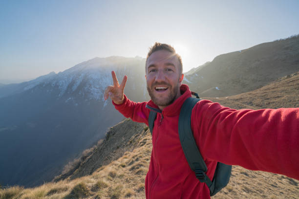 istock Hiker male taking selfie portrait on mountain trail 688551268