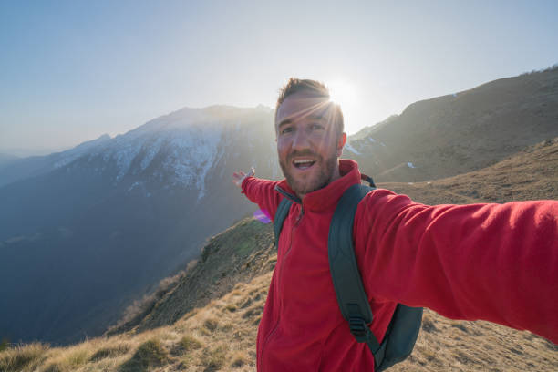istock Young man taking selfie portrait with mountain landscape 688551280