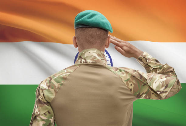 istock Dark-skinned soldier with flag on background - India 688551488