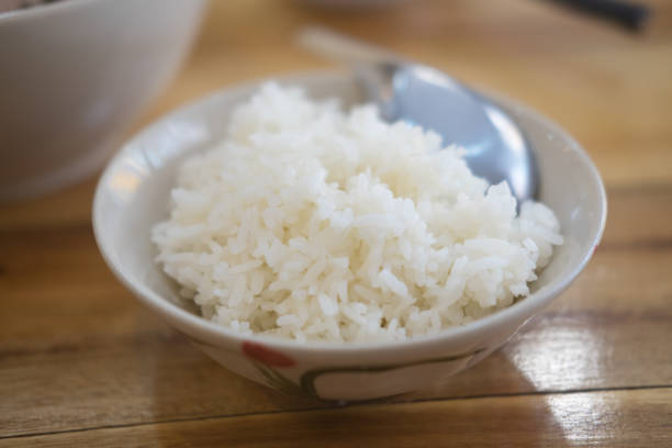 Cooked white rice in a bowl on wood table