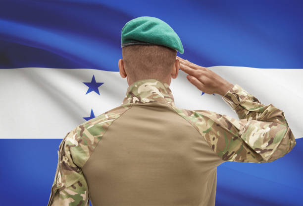 istock Dark-skinned soldier with flag on background - Honduras 688552736