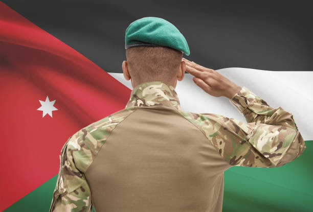 Dark-skinned soldier with flag on background - Jordan stock photo