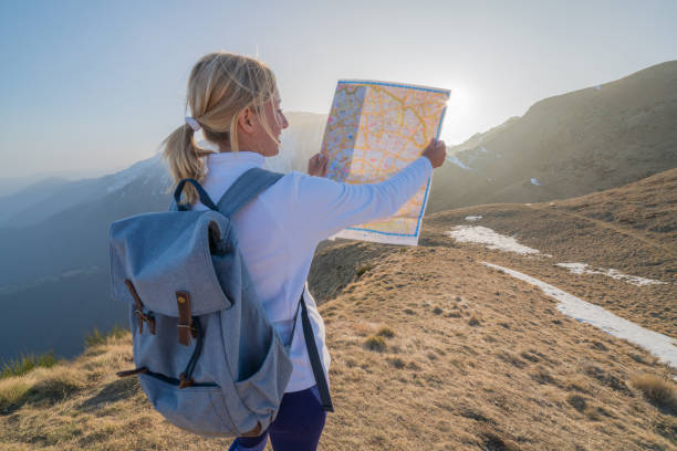 istock Young woman hiking in Switzerland looking at map 688553986
