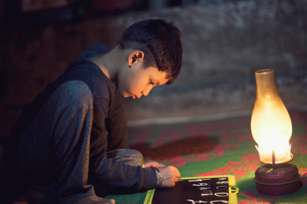 istock Boy studying in oil lamp 688554210