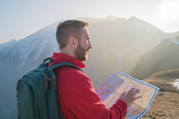 istock Hiker male looking for directions on mountain trail 688554246