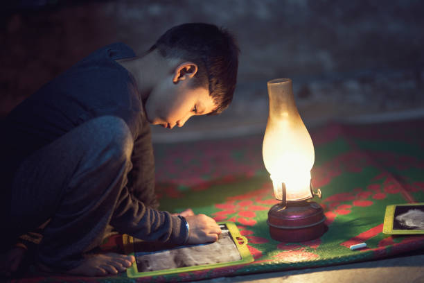 istock Boy studying in oil lamp 688554320