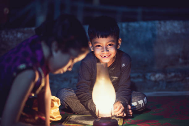 menino e menina estudando em lâmpada de óleo - india slum poverty family - fotografias e filmes do acervo