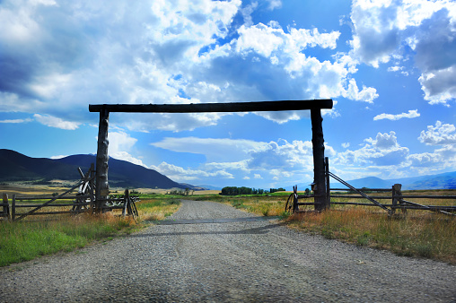 Popular architecture for a country entry, this weathered log construction spans driveway to ranch.   Montana ranches often use this type of rustic architecture.
