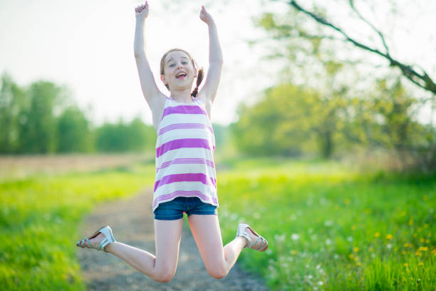 jumping for joy in the sun - nostalgia joy laughing wellbeing imagens e fotografias de stock