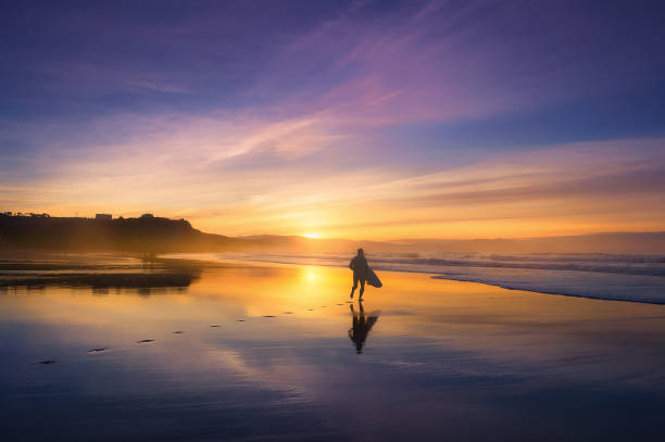 surfer na plaży o zachodzie słońca - men footprint beach sunset zdjęcia i obrazy z banku zdjęć