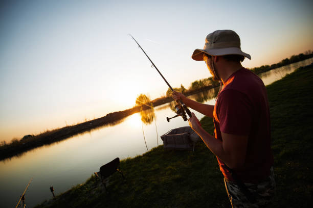 istock Men fishing in sunset and relaxing while enjoying hobby 688563476