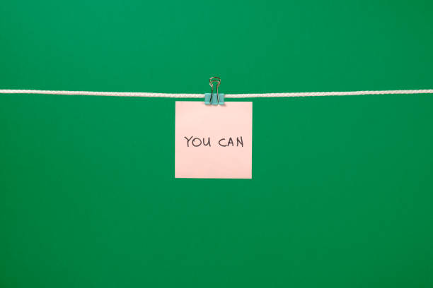 istock Pink paper sheet on the string with text You Can over colorful background 688577814