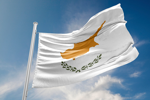 Cyprus flag is waving at a beautiful and peaceful sky in day time while sun is shining. 3D Rendering