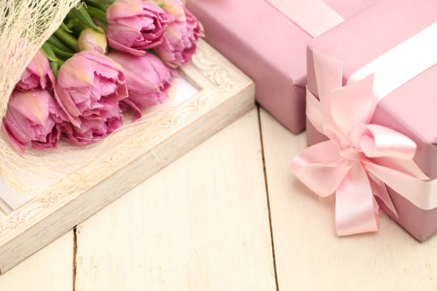 istock Flowers and gift box on wooden background with copyspace 688588250