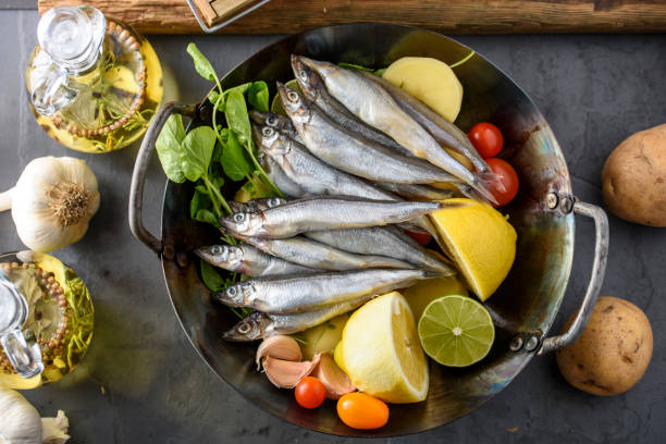 Fresh Sardines in wok Fresh fish with vegetables and spices in wok sardine photos stock pictures, royalty-free photos & images