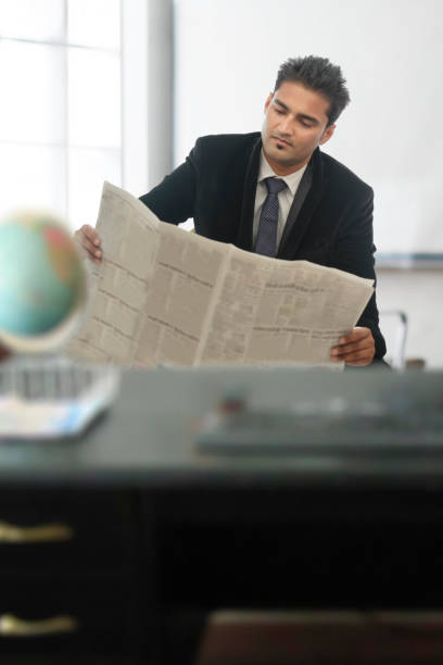 istock Businessman reading newspaper in office 688588682