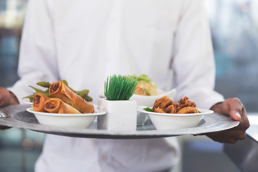 Server holding fresh food platter at a cafe