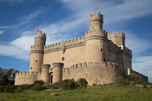 Manzanares el Real, Spain - June 9, 2013: View of the New Castle of Manzanares el Real against a cloudy sky. Also known as Castle of los Mendoza, it's a palace-fortress erected in the 15th century in Romanesque-Mudéjar style in the town of Manzanares el Real in Madrid, Spain. It currently operates as a museum, and it appears in the movie \