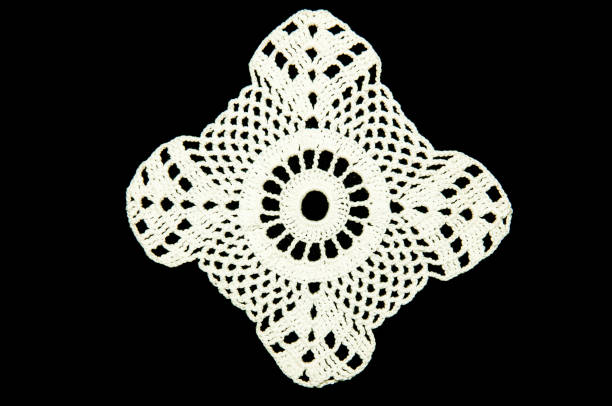 istock White crocheted coaster on black background. Not isolated. Lace doily. 688594242