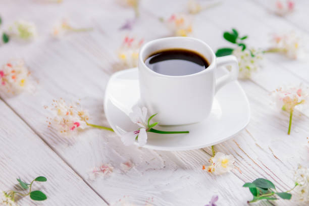 istock Cup of coffee surrounded with flowers 688598520