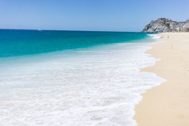 Waves at a sandy beach with footsteps on the Pacific coast near Todos Santos, state of Baja California Sur, Mexico