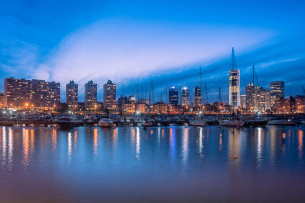 Montevideo skyline from river Skyline of Montevideo from Puerto del Buceo at dusk. Finance and business buildings as well as luxury residential towers. Building lights reflections on water. uruguay photos stock pictures, royalty-free photos & images