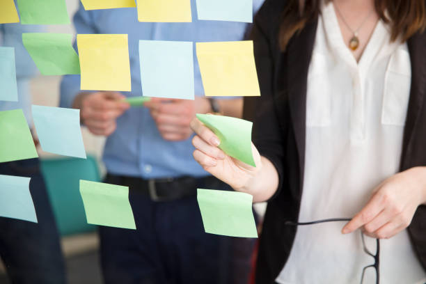 istock Midsection Of Businesswoman Sticking Note While Standing By Executive 688604974