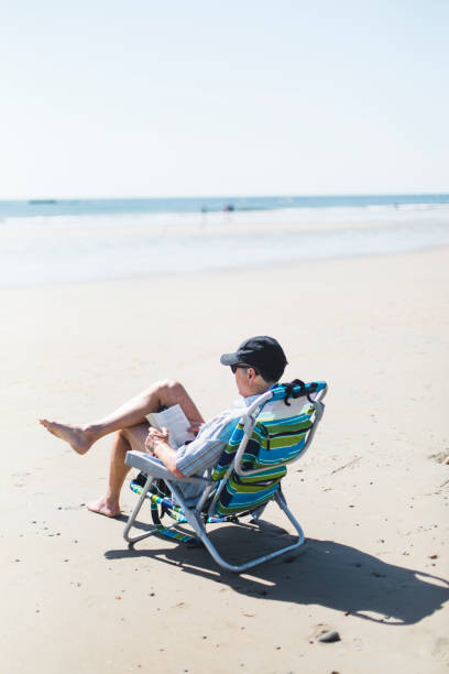 istock A mature man reading a book on the beach 688634032