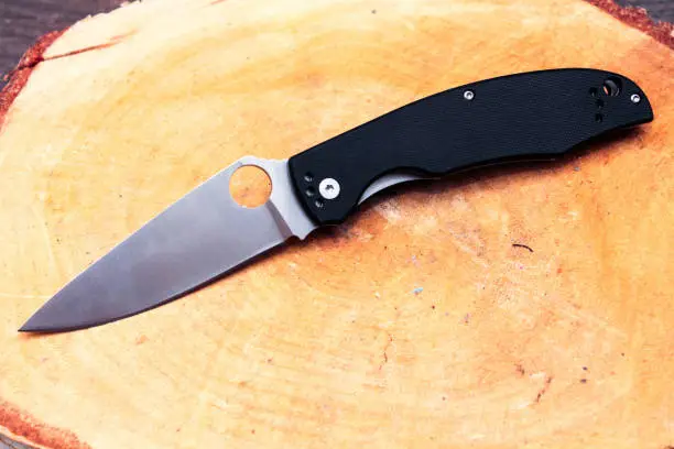 Photo of Knife with a triangular blade. White blade and black handle.
