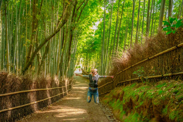 istock Woman jumping in Bamboo Forest 688663254