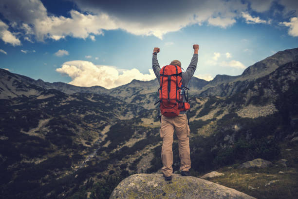 Traveler hiking in mountains and enjoying a view from above