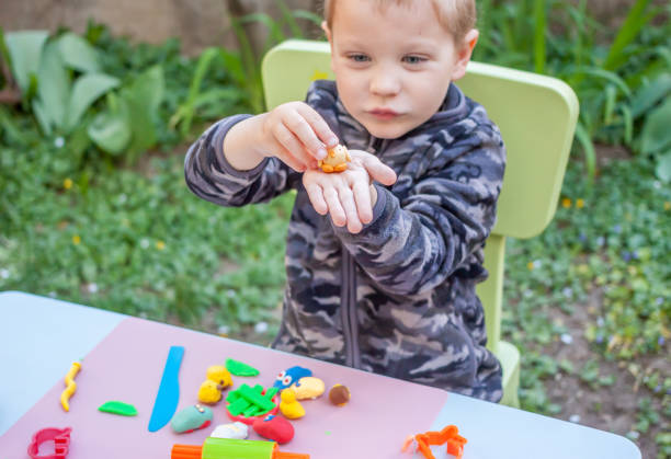 istock cute little boy playing with plasticine 688725512