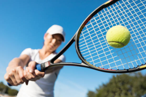 close up of female tennis player hitting the ball - tennis court tennis racket forehand imagens e fotografias de stock