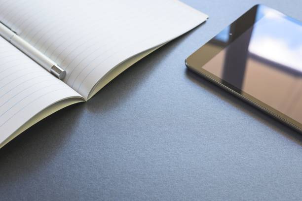 istock An opened notebook with a pen and mobile phone, on dark grey background, scene work or study. 688745702