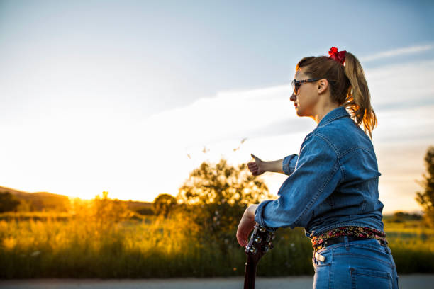 istock Woman hitchhiking on road 688767658