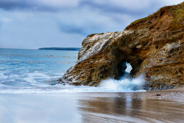A gap in the rocky cliff section at Spit beach, Cornwall creates a huge rush of water through the gap.
