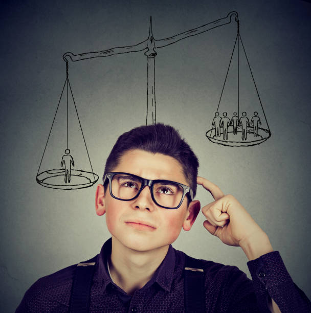 istock Man making a decision with scale above head and people on a balance 688771506